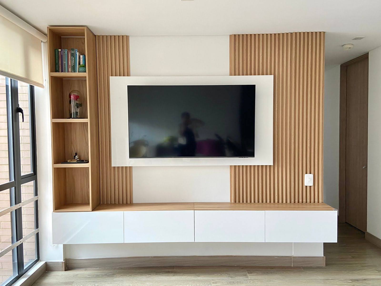 Centro de entretenimiento flotante en madera natural con panel ranurado en un apartamento de Bogotá